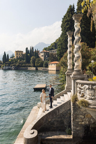 Bride and groom on a lakeside stone terrace